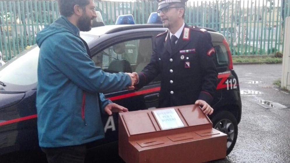 Il parroco don Lorenzo Lodi riceve la cassetta delle offerte ritrovata dai carabinieri