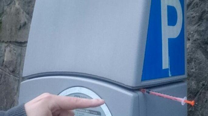 Una siringa infilata nel parcometro