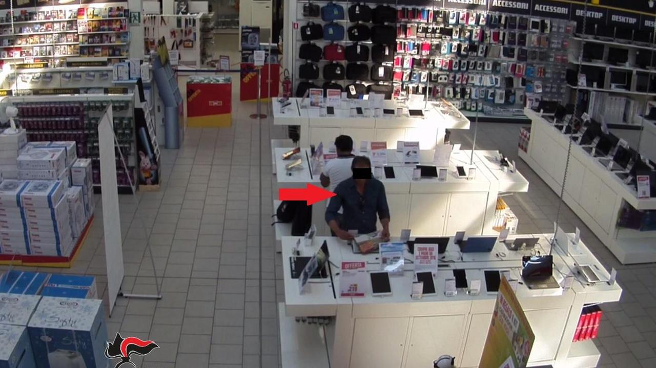 Uno dei georgiani mentre nasconde un pc in un giornale