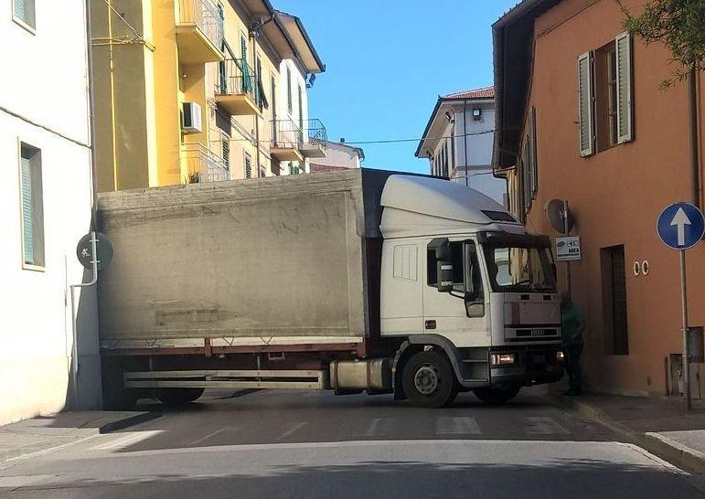 Tir incastrato fa danni e se ne va