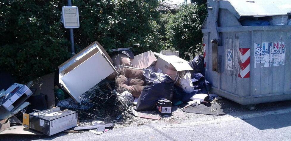 Mobili e divani al lato dei cassonetti
