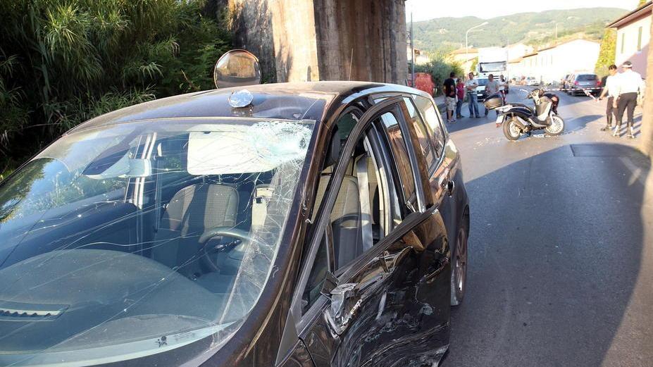 I danni sulla Renault dopo lo scontro e, dietro, lo scooter coinvolto nell’incidente (Foto Paolo Nucci)