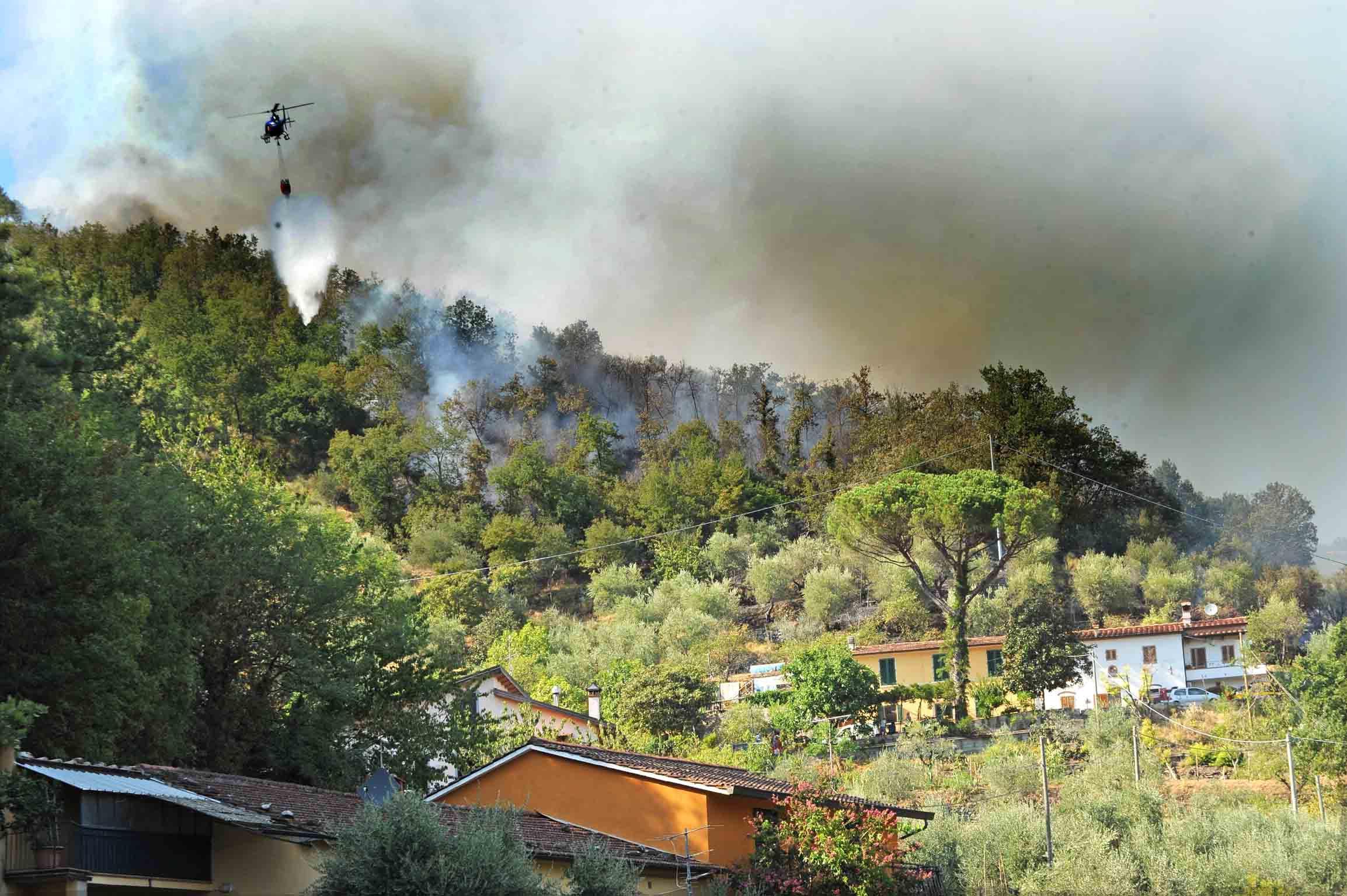 Un elicottero impegnato a spegnere un incendio in collina (archivio)