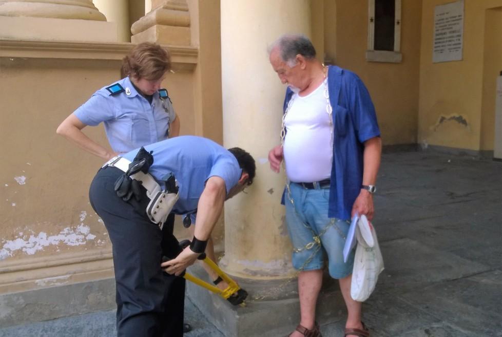 Protesta incatenandosi davanti al Comune