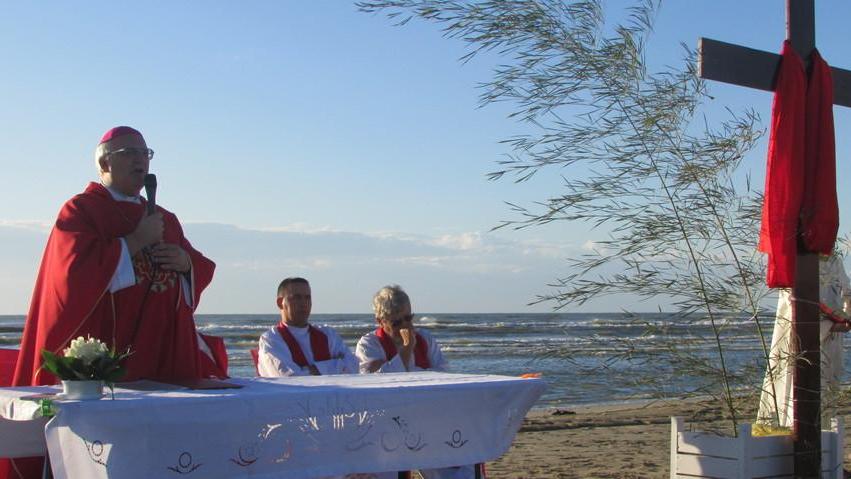 All’alba in spiaggia col vescovo: la fede non cede al maltempo