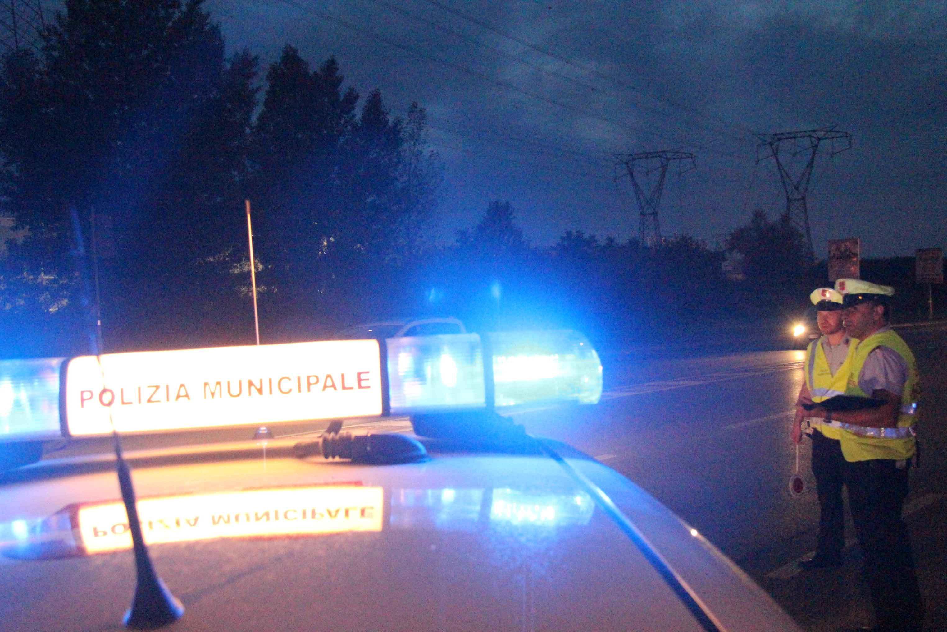 Un'auto della polizia municipale fa i rilievi di un incidente avvenuto di notte