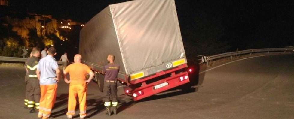 Vigili del fuoco e operai studiano come "liberare" il tir incastrato in curva