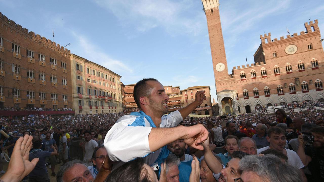 Il fantino Carlo Sanna portato in trionfo dai contradaioli dell'Onda