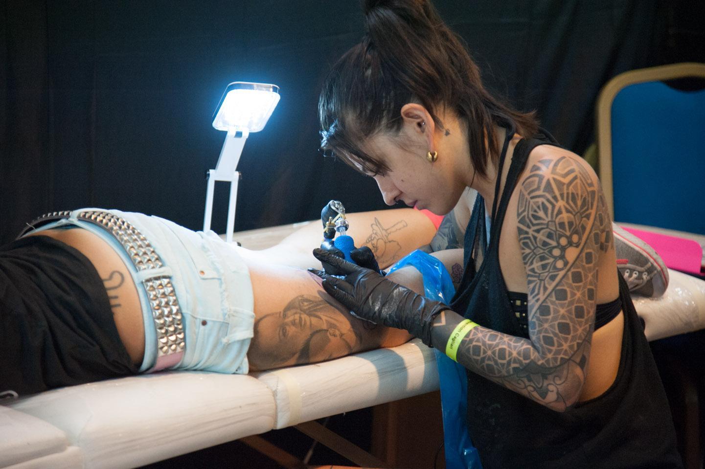 Una tatuatrice all'opera (foto Mario Rosas)