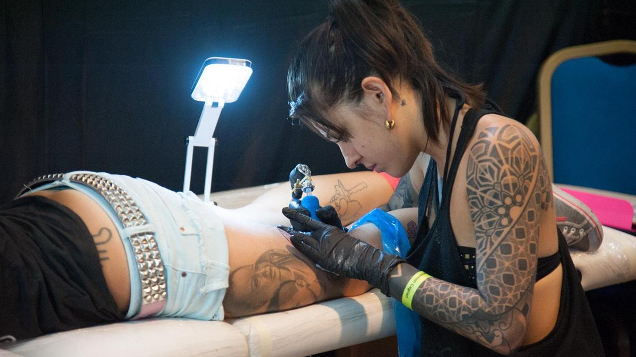 Una tatuatrice all'opera (foto Mario Rosas)