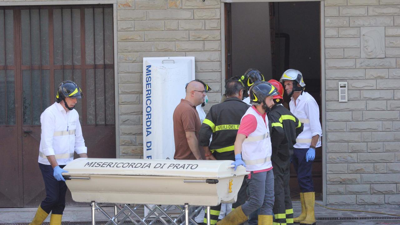 La rimozione di una delle due salme dall'appartamento della Tignamica (foto Batavia)