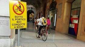 Ciclista pedala sotto i portici: è vietato