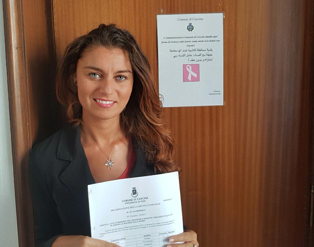 La sindaca Ceccardi e, alle sue spalle, il cartello in italiano e arabo contro la violenza di genere