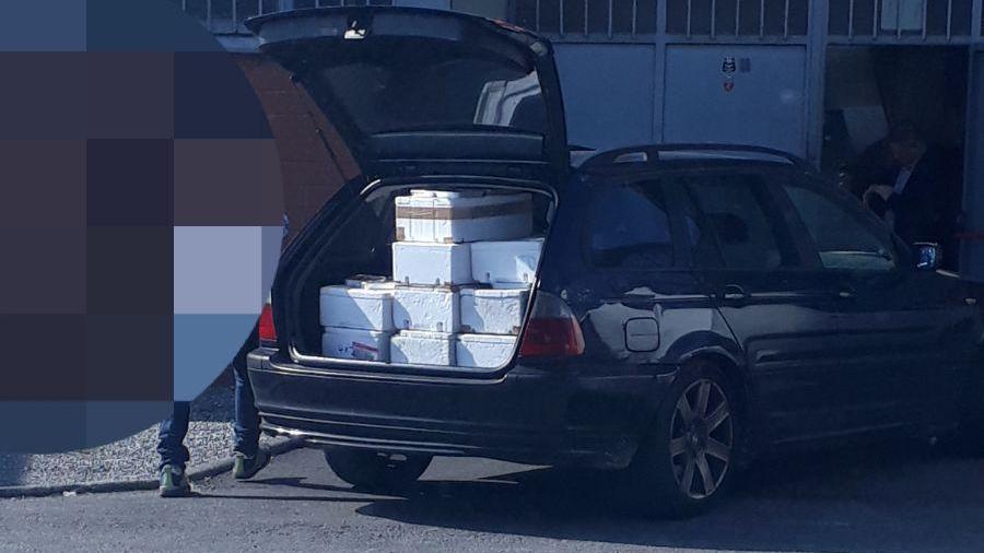La Bmw col carico di contenitori di cibo per gli operai cinesi di una confezione