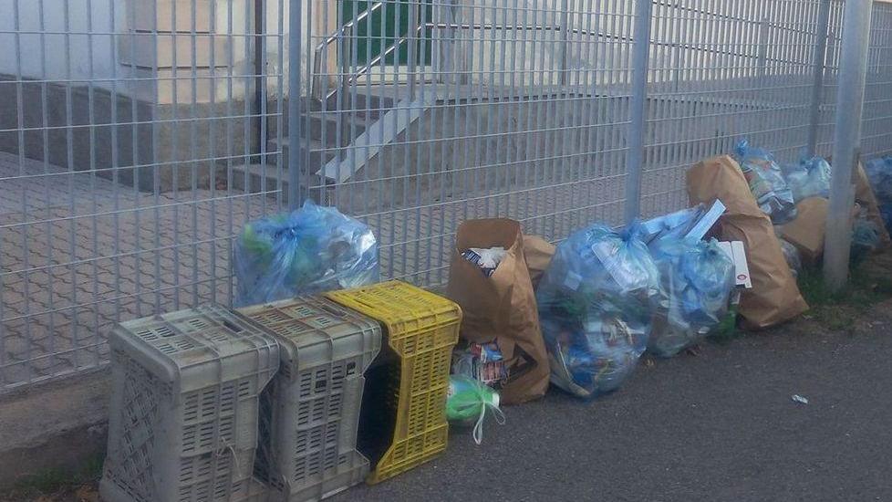 I rifiuti depositati per il ritiro sul marciapiede della scuola elementare