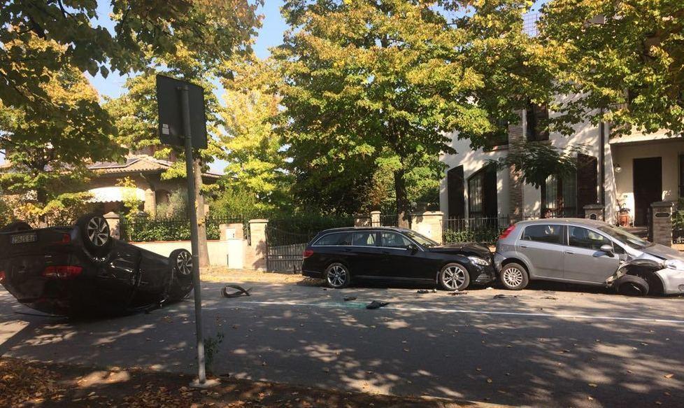 Sbatte sulle auto in sosta e si ribalta