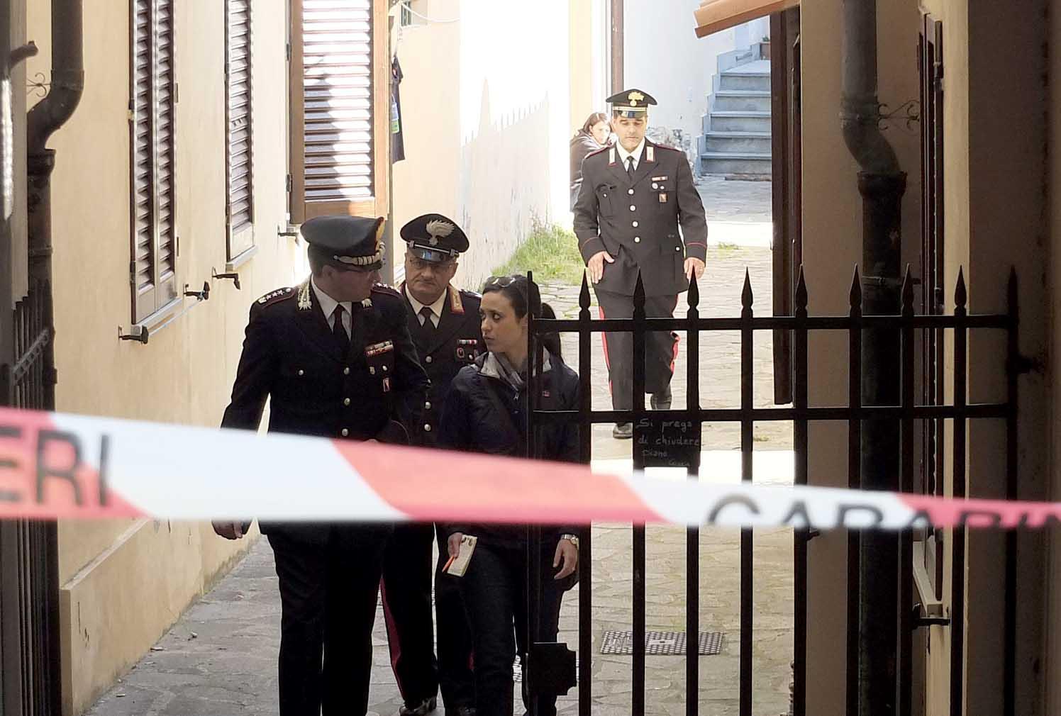 Gli investigatori escono dall'appartamento in cui è morto il pensionato (Foto Muzzi)