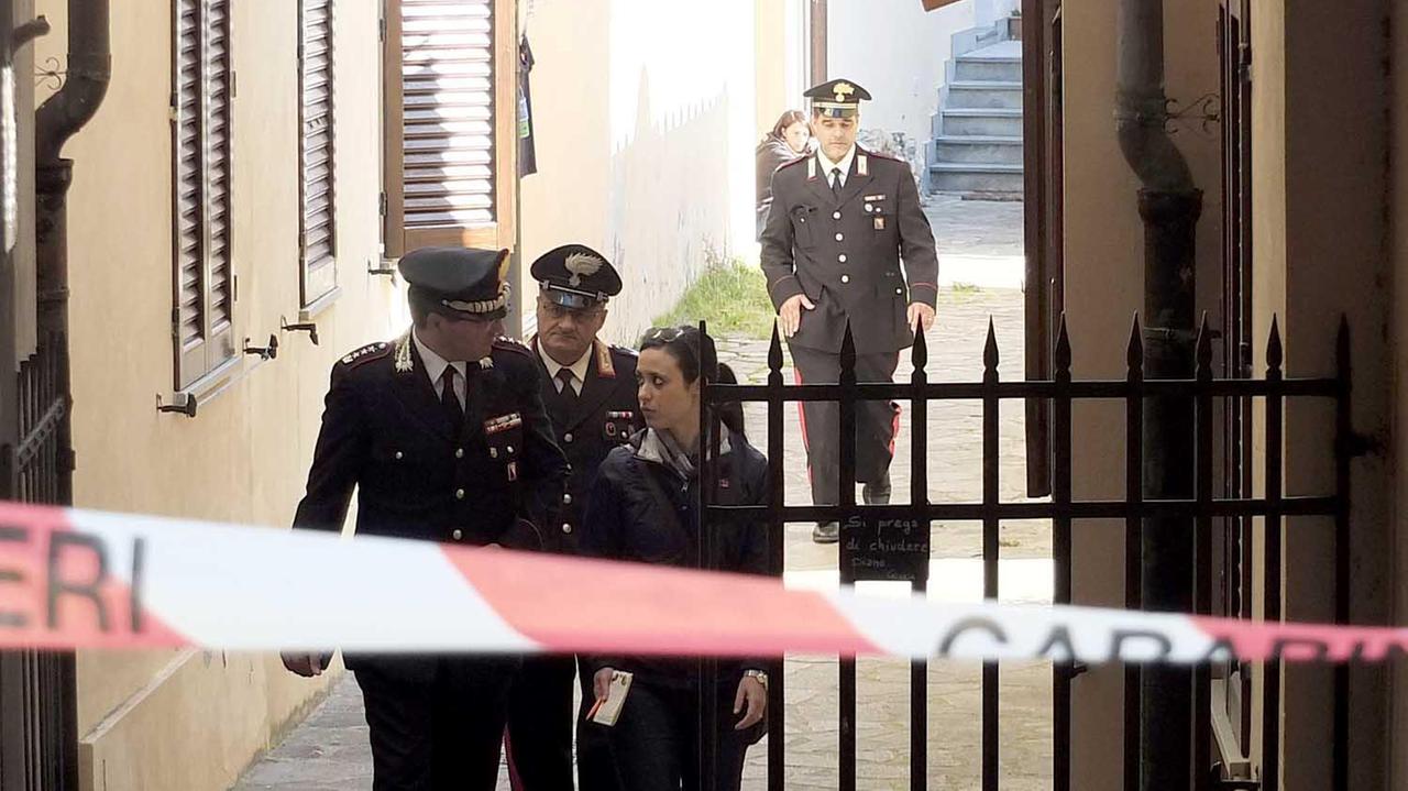 Gli investigatori escono dall'appartamento in cui è morto il pensionato (Foto Muzzi)
