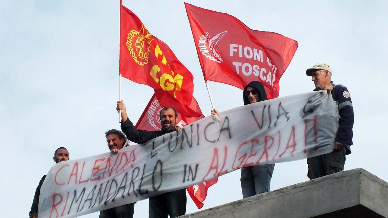Operai della Fiom con gli striscioni sul tetto di Aferpi (foto Paolo Barlettani)