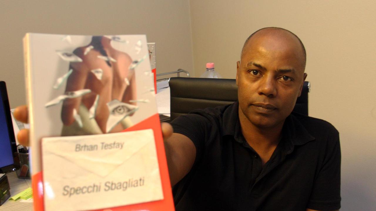 Lo scrittore etiope Brhan Tesfay e uno dei suoi libri