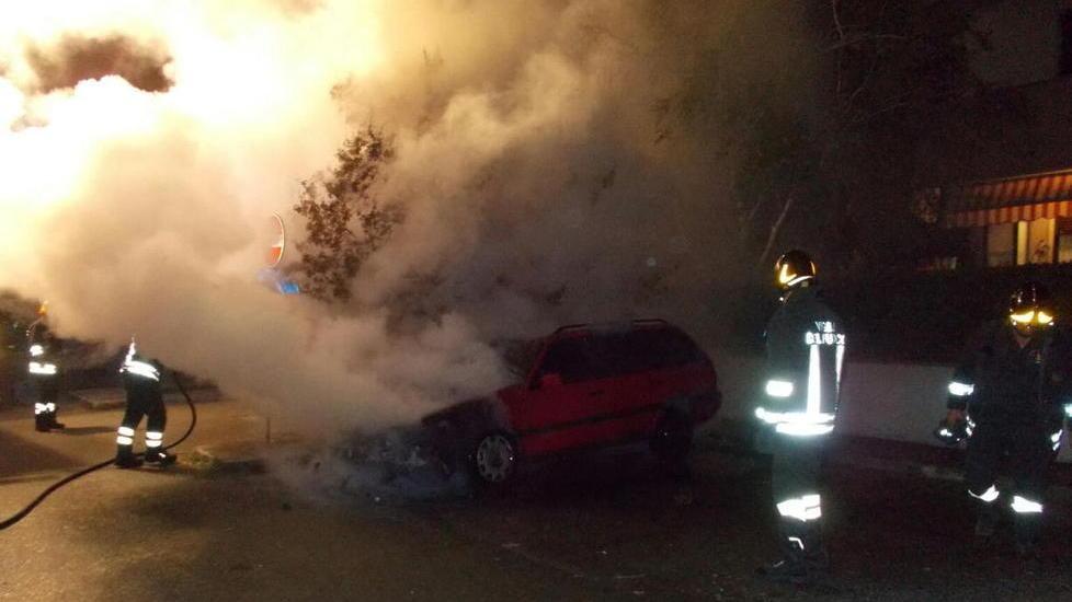I vigili del fuoco impegnati nelle operazioni di spegnimento dell'incendio dell'auto