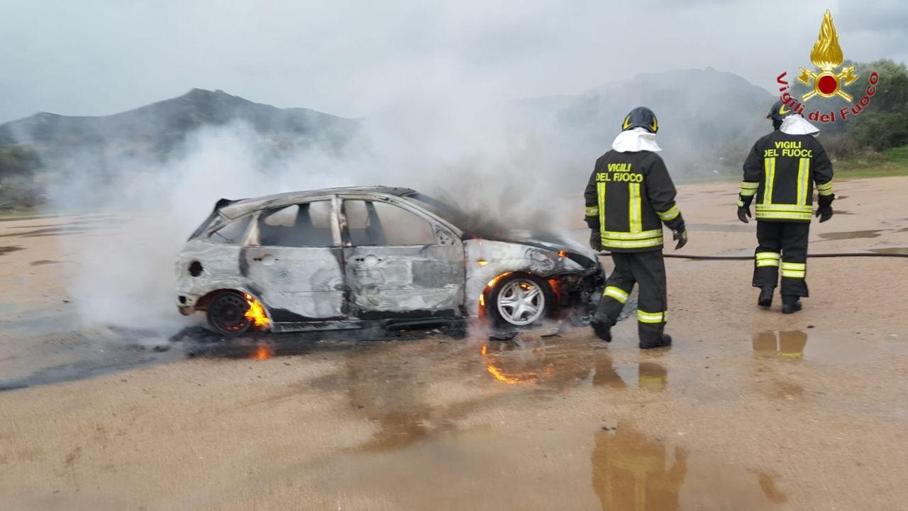 I vigili del fuoco intervengono per spegnere l'auto incendiata