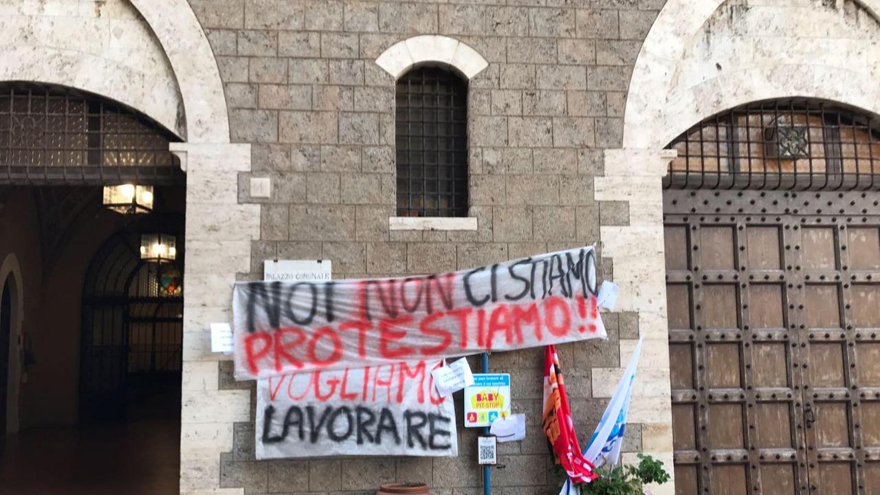 Gli striscioni delle lavoratrici dell'indotto sul muro del Comune