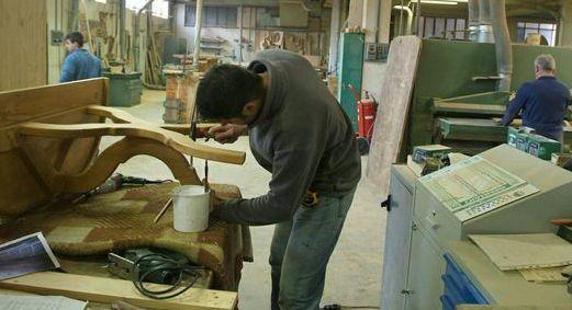 Falegname al lavoro in una fabbrica di mobili: il settore continua ad essere in grave crisi (foto d’archivio)
