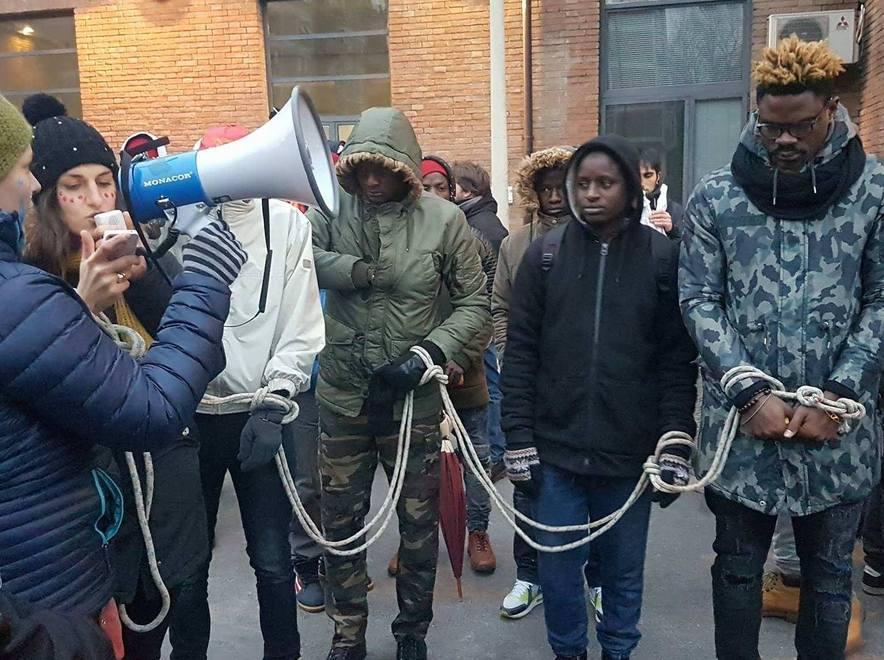 Reggio Emilia, i migranti sfilano legati: «Non siamo in vendita» 