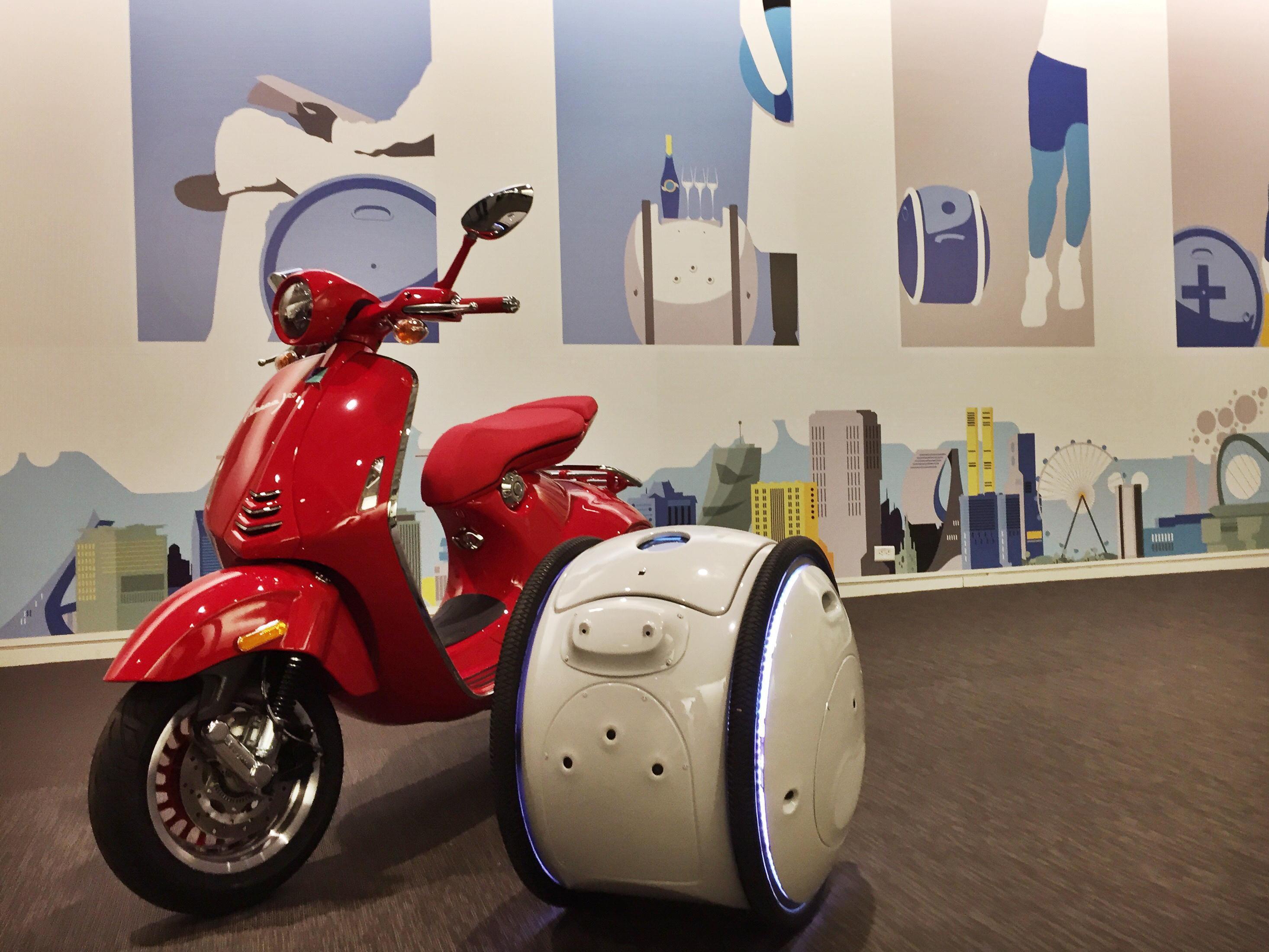 Gita, la valigia robotica, accanto a una Vespa