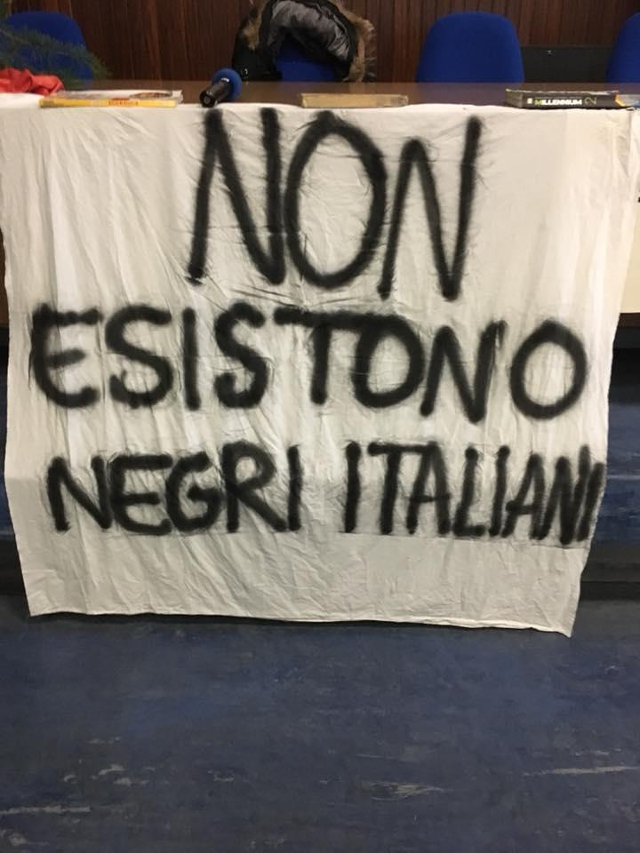 Lo striscione appeso al tavolo del dibattito