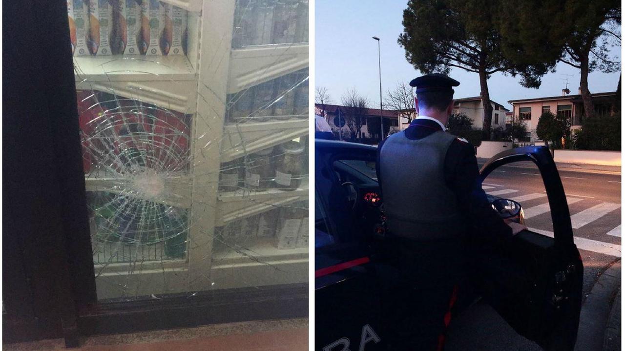 La vetrata della macelleria presa a mazzate, a destra una pattuglia dei carabinieri