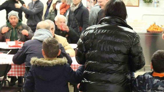 Monsignor Camisasca serve i poveri a tavola