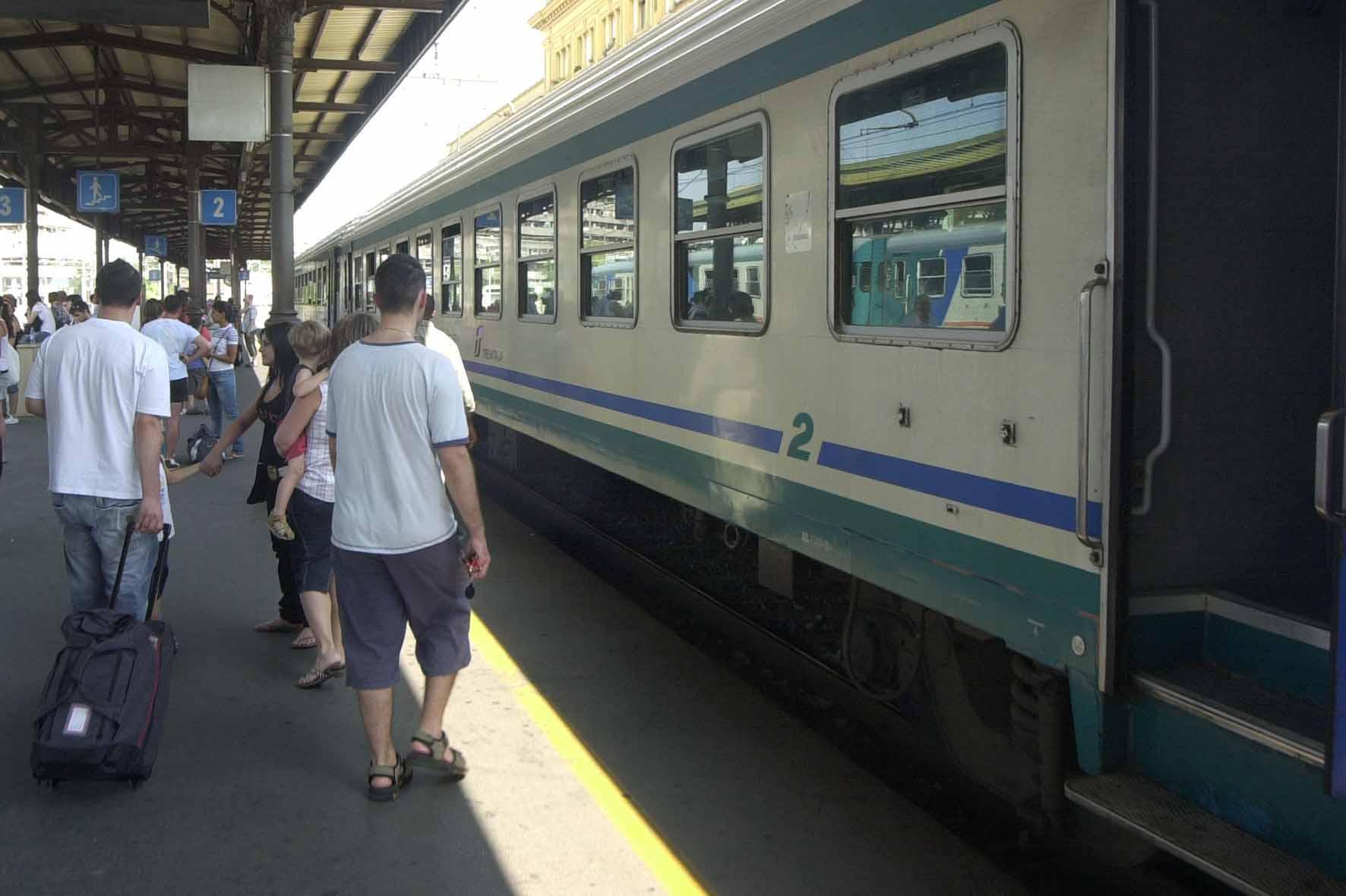 Pendolari salgono su un treno in stazione centrale a Modena