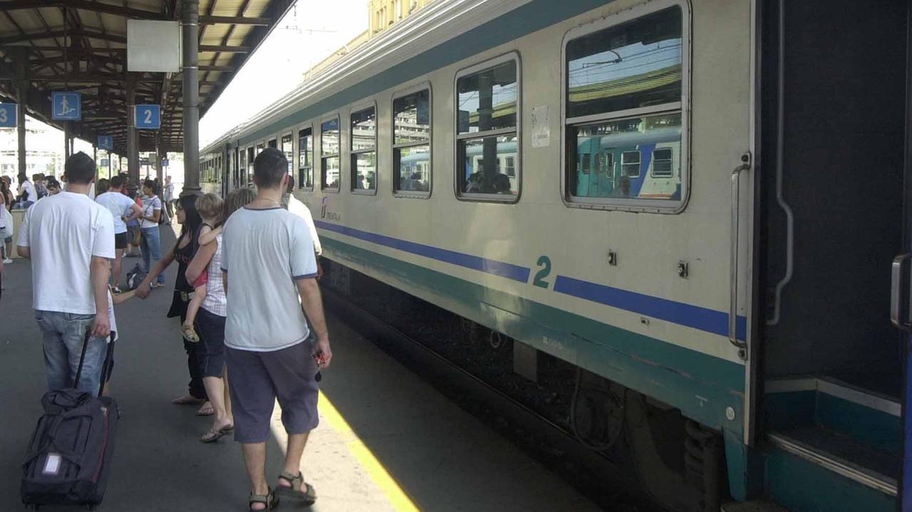 Pendolari salgono su un treno in stazione centrale a Modena