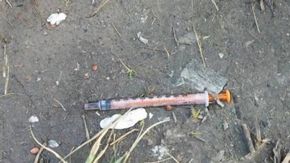 Segnala una siringa abbandonata e viene minacciata