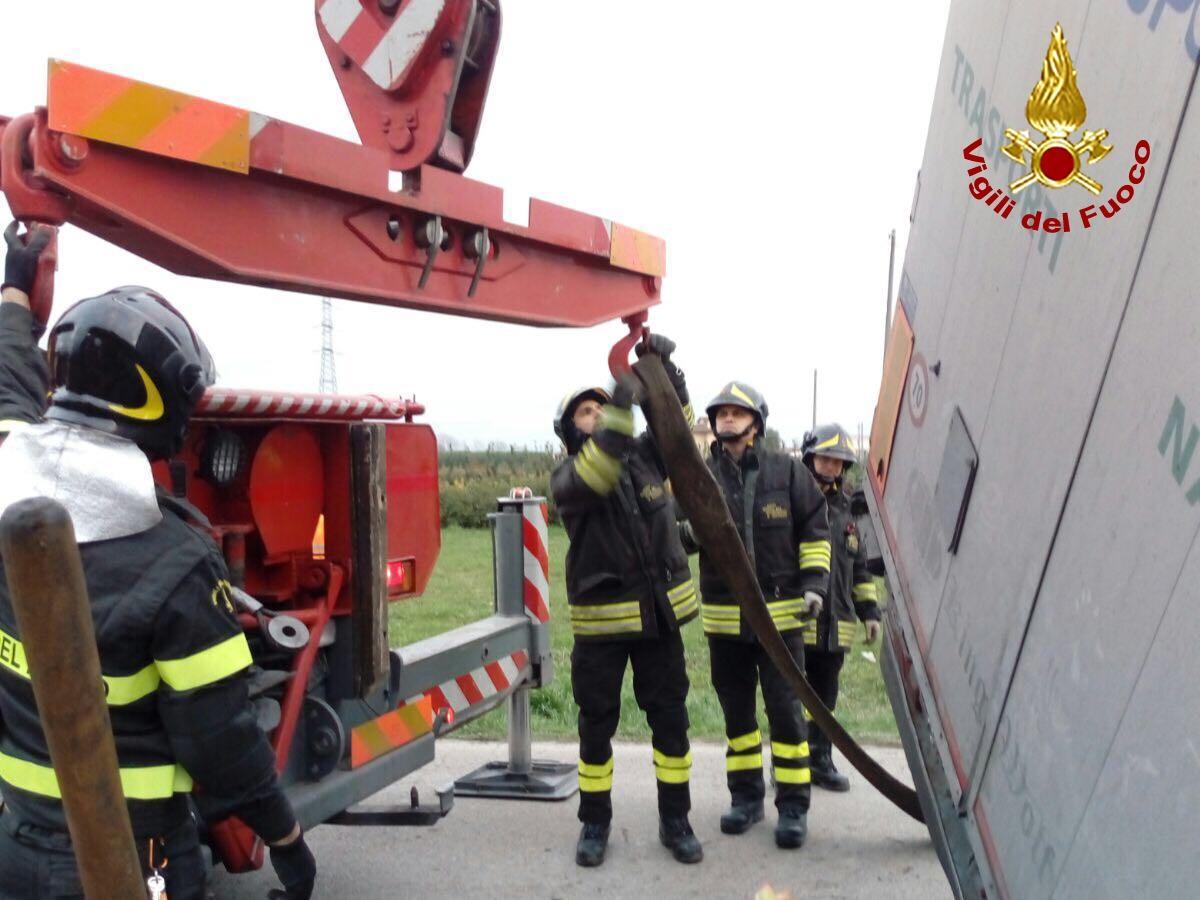 I vigili del fuoco imbragano il rimorchio carico di cartone finito fuori strada