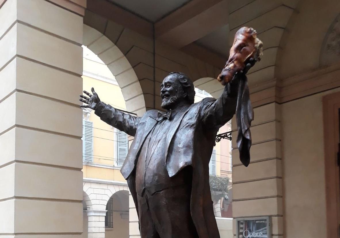 Modena, una testa di porchetta attaccata sulla statua di Pavarotti 