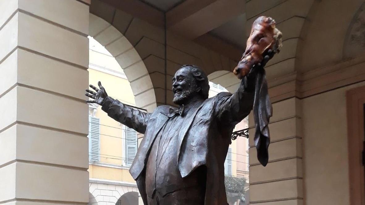 Modena, una testa di porchetta attaccata sulla statua di Pavarotti