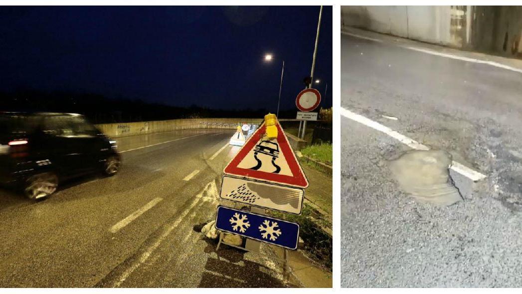 I cartelli che segnalano il pericolo e una buca all'altezza del sottopassaggio