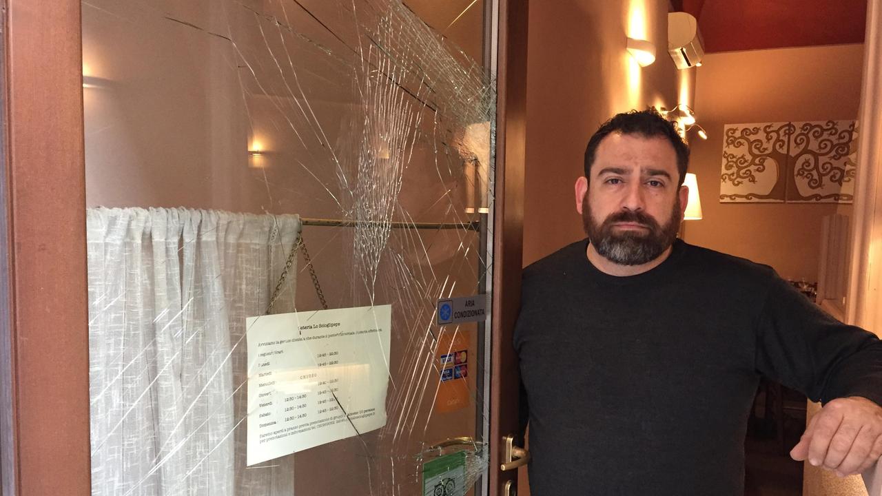 Il titolare dell'osteria "Lo Scioglipepe", Giorgio Benedetti, con la vetrina spaccata