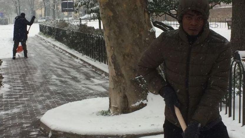 Profughi al lavoro spalano la neve