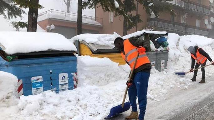I profughi al lavoro per sgomberare la neve