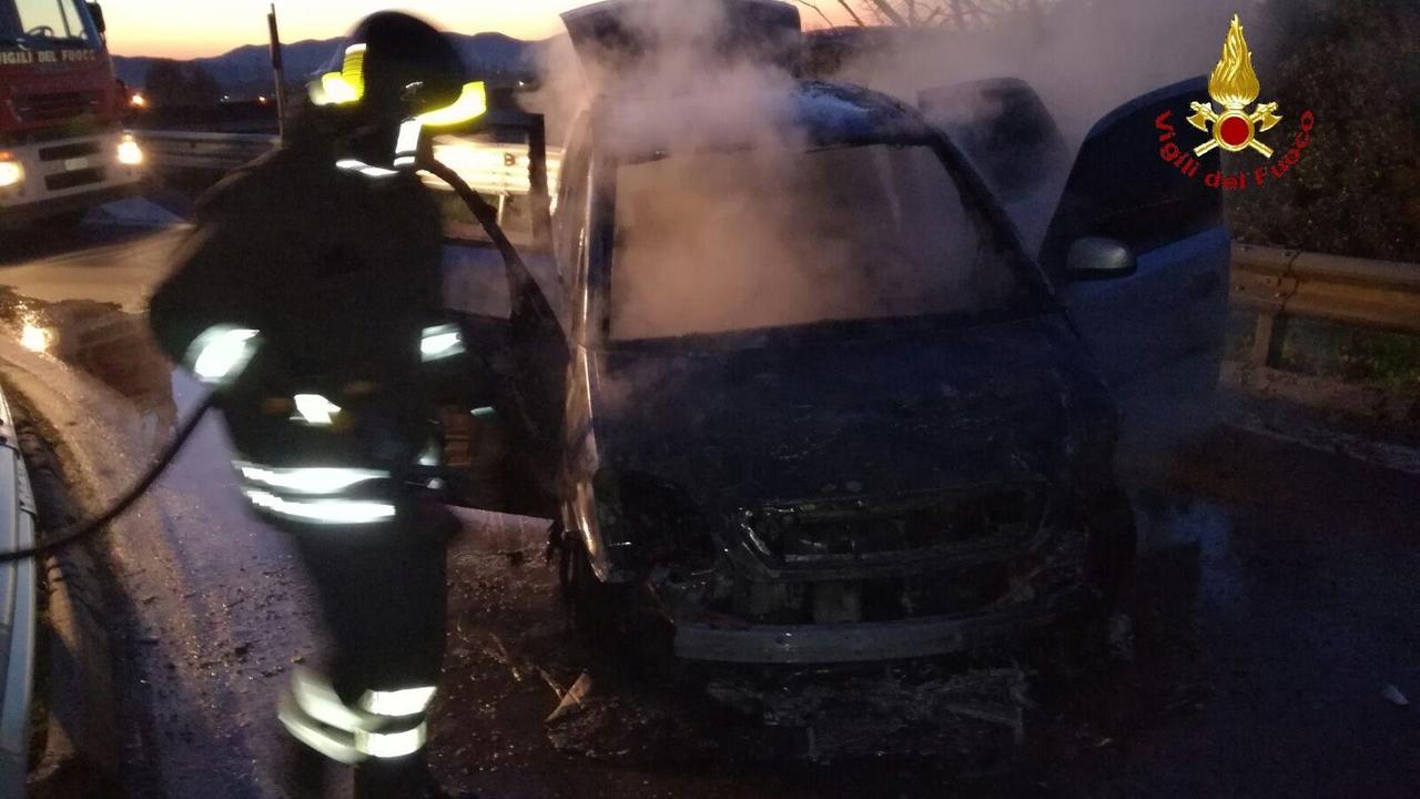 I vigili del fuoco spengono le fiamme sull'auto andata a fuoco dopo l'impatto con il guard rail