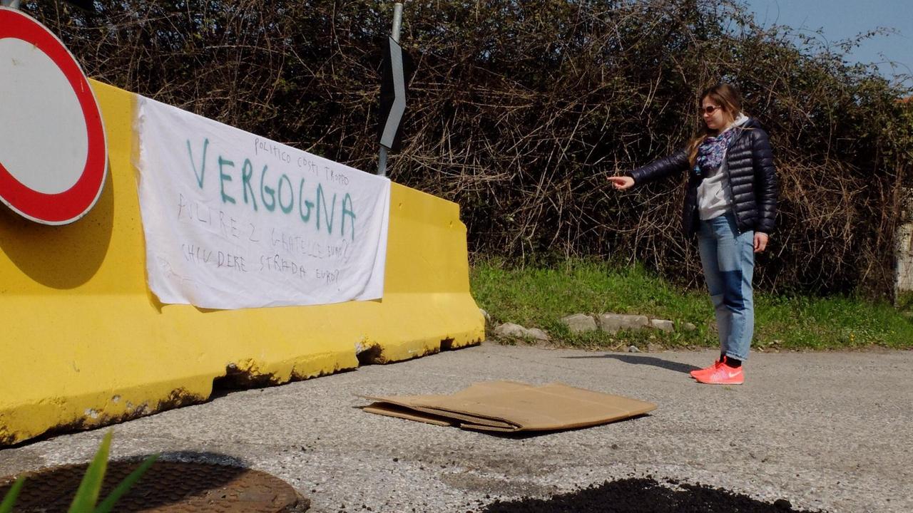 Uno striscione di protesta sulla barriera in cemento che chiude via Del Becarello (foto Sproviero/Batavia)