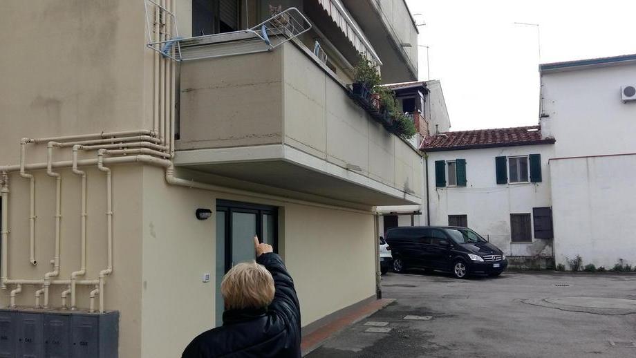 La signora rapinata mentre indica il balcone da dove sono entrati i due banditi