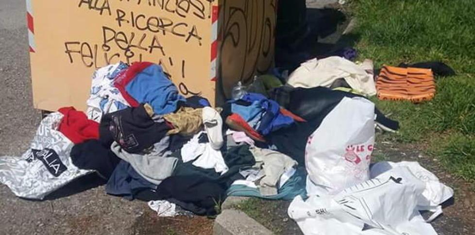 Vecchi abiti accanto al cassonetto
