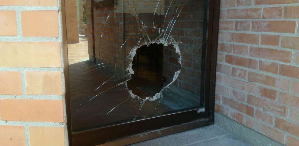 Il vetro rotto della porta laterale della chiesa di Ghezzano