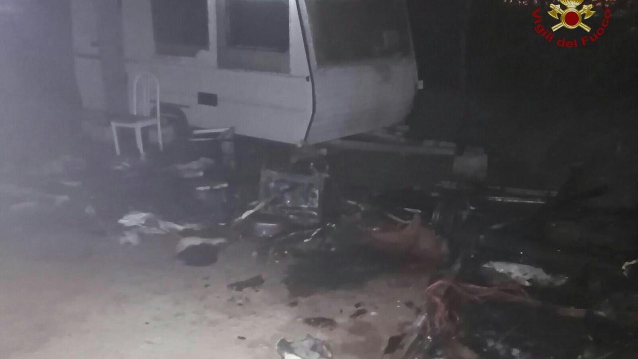 Il luogo dell'incendio con una roulotte bruciata