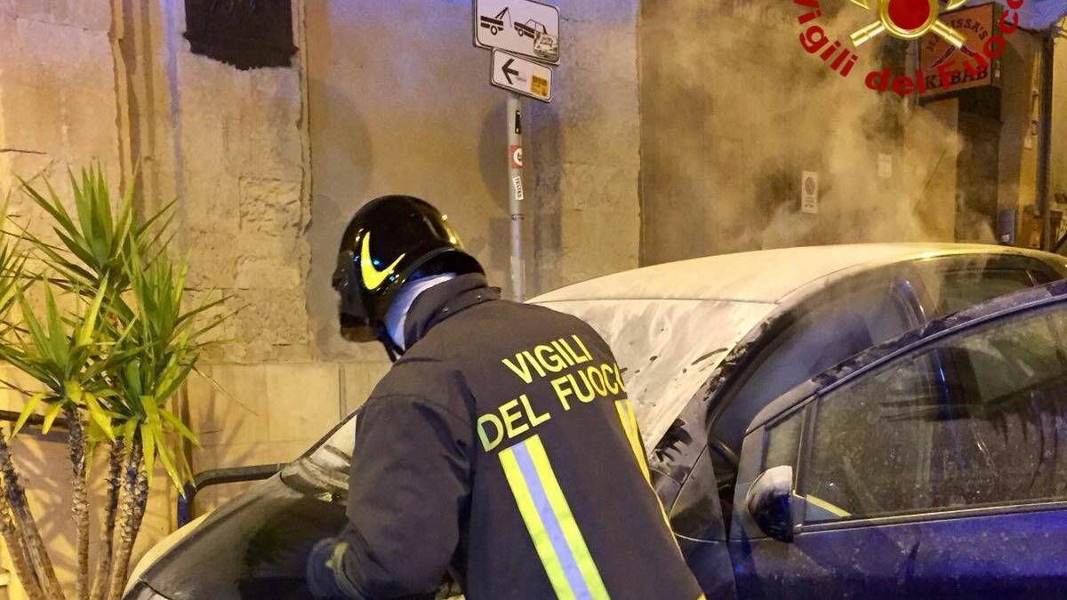 L'intervento dei vigili del fuoco sull'auto incendiata in via Torino (foto Rosas)